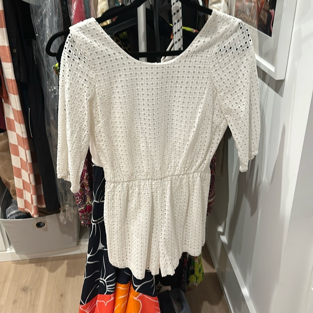 White shorts romper with open back ties. 
Worn 1x for wedding party.